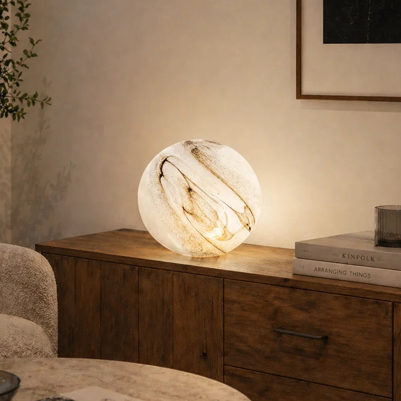 Modern living room with a textured round lamp on a wooden side table.